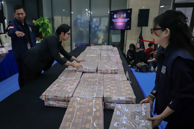 Petugas menata uang sejumlah Rp 58 miliar untuk ditunjukkan saat konferensi pers terkait penyerahan tanggung jawab dan eksekusi harta kekayaan hasil TPPU yang berasal dari praktik judi online di Bareskrim Polri, Jakarta, Kamis (5/2/2026). Foto: Jamal Ramadhan/kumparan