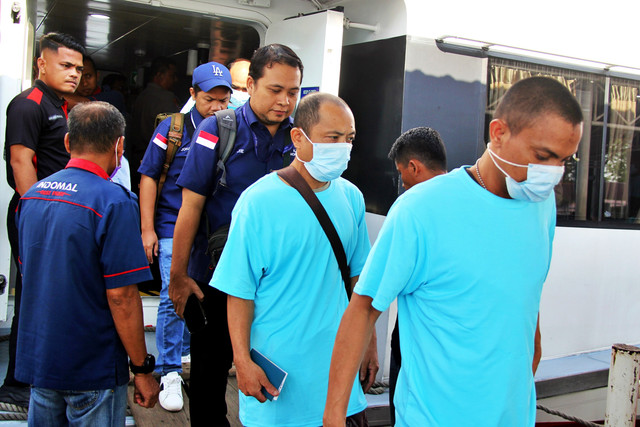 Staf KJRI Johor Bahru bersama pekerja migran Indonesia (PMI) keluar dari kapal setibanya di Pelabuhan Pelindo Dumai, Riau, Sabtu (7/3/2026). Foto: Aswaddy Hamid/ANTARA FOTO