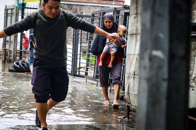 Warga berjalan melintasi banjir yang merendam ruas Jalan Kapten Pierre Tendean usai hujan deras terjadi di kawasan Mampang, Jakarta Selatan, pada Minggu (8/3/2026). Foto: Iqbal Firdaus/kumparan