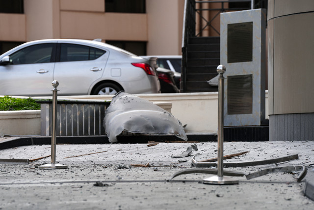 Serpihan besar dan puing-puing berserakan di jalan di luar hotel Crown Plaza yang rusak, di Manama pada 1 Maret 2026. Foto: Fadhel Madan/AFP