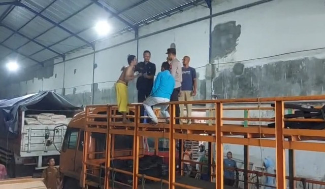Fauzi Abdillah seorang ODGJ, dibujuk turun dari atas truk oleh Aiptu Wido, anggota Polsek Panarukan. Foto: Dok. Istimewa