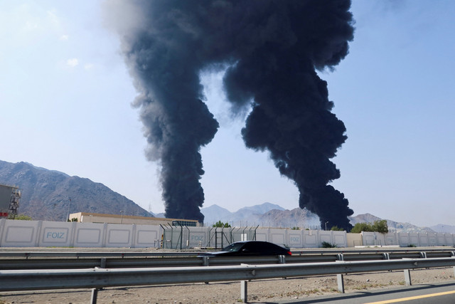 Asap mengepul di zona industri minyak Fujairah yang terkena serangan drone di Fujairah, Uni Emirat Arab, Sabtu (14/3/2026). Foto: REUTERS