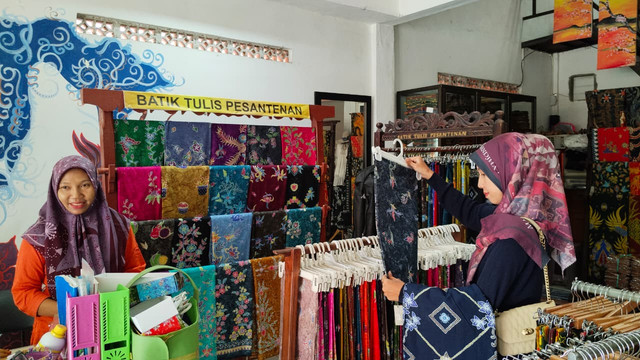 Dua calon pembeli sedang memilih motif Batik Tulis Pesantenan di toko yang berada di Desa Mojomulyo, Kecamatan Tambakromo, Kabupaten Pati, Sabtu (14/3). Foto: kumparan