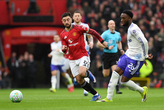 Pemain Manchester United Bruno Fernandes berebut bola dengan pemain Aston Villa Lamare Bogarde pada pertandingan Liga Inggris di Old Trafford, Manchester, Inggris, Minggu (15/3/2026). Foto: Peter Powell/REUTERS