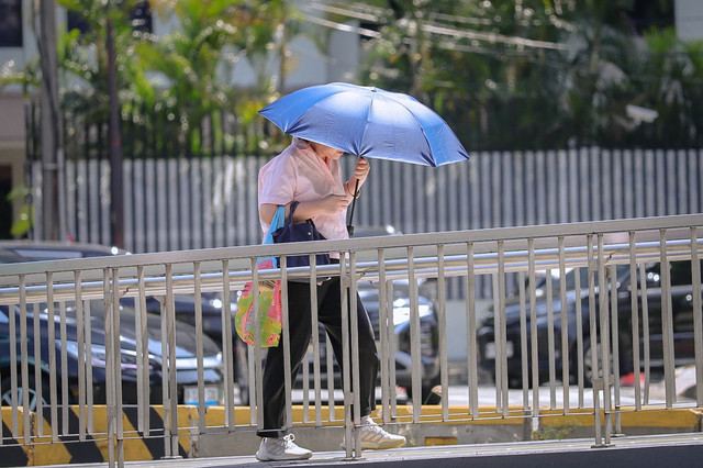 Warga menggunakan payung saat berjalan di trotoar kawasan Jalan Jenderal Sudirman, Jakarta, Senin (16/3/2026). Foto: Jamal Ramadhan/kumparan