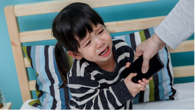 Seorang anak yang kecanduan smartphone. Foto: Shuttershock
