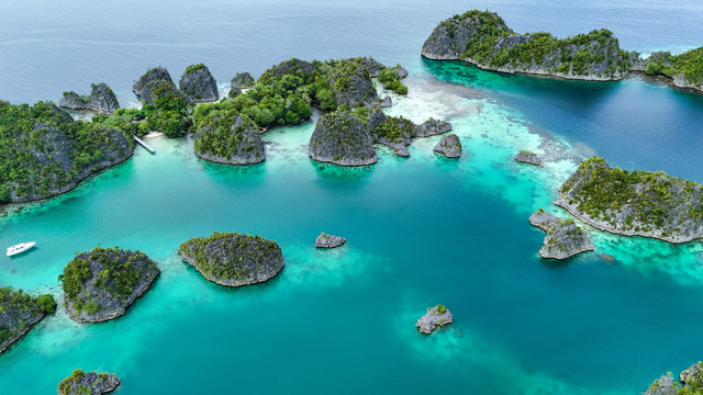 Tampilan udara gugusan Kepulauan Piaynemo di Raja Ampat, Indonesia, menampilkan laguna biru kehijauan, pulau karst hijau, serta lanskap laut tropis yang menjadi simbol destinasi eksotis dan petualangan. Foto: LvDaryna/Shutterstock
