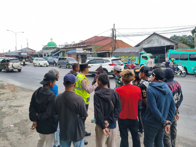 Sejumlah 'Pak Ogah' yang nekat membuka paksa putaran arah atau U-Turn di turunan Flyover Jomin, Kecamatan Kotabaru, Karawang, akhirnya ditertibkan polisi. Foto: Dok. Istimewa