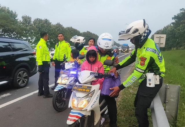 Petugas kepolisian Satlantas Polres Indramayu saat membantu satu keluarga pemudik di Tol Cipali KM 134, Selasa (17/3/2026) Foto: Dok. Istimewa