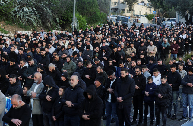 Sejumlah warga Palestina melaksanakan salat Idul Fitri di pinggir jalan, Jumat (20/3). Foto: Ammar Awad/REUTERS