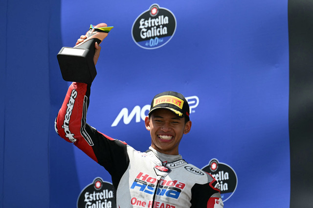 Pebalap Tim Honda Asia Veda Pratama merayakan kemenangan di podium Grand Prix Moto3 Brasil di sirkuit internasional Ayrton Senna di Goiania, negara bagian Goias, Brasil, Minggu (22/3/2026). Foto: Evaristo SA / AFP