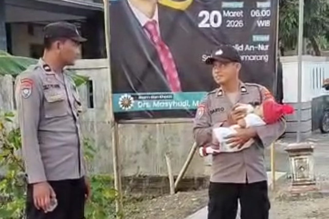 Polisi di Ngawi gendong bayi jemaah saat salat Idul Fitri. Foto: Dok. Istimewa