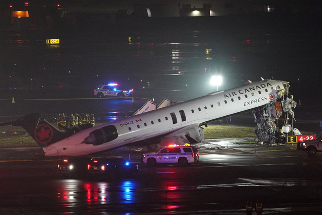 Tim penyelamat bekerja di sekitar pesawat Air Canada Express yang bertabrakan dengan  truk pemadam kebakaran di Bandara LaGuardia di Queens, New York, AS, Senin (23/3/2026). Foto: Bing Guan/REUTERS