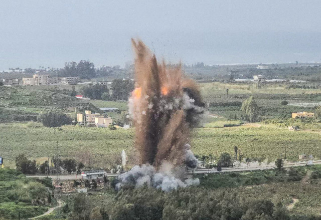Sebuah bola api membumbung dari lokasi serangan udara Israel yang menghantam Jembatan Qasmiyeh di wilayah selatan Lebanon, Minggu (22/3). Foto: KAWNAT HAJU/AFP