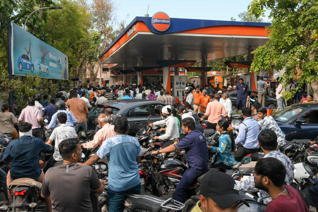 Antrean panjang terlihat di sejumlah stasiun pengisian bahan bakar di Ahmedabad pada Senin (23/3), menyusul gangguan pasokan energi akibat konflik di Timur Tengah.
 Foto: SHAMMI MEHRA/AFP