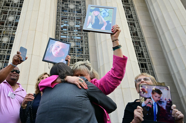 Orang tua dan kerabat korban membentangkan spanduk berisi nama-nama korban di luar Los Angeles Superior Court, Rabu (25/3/2026), usai putusan sidang terkait dampak media sosial terhadap kesehatan mental.
 Foto: Frederic J. Brown/AFP