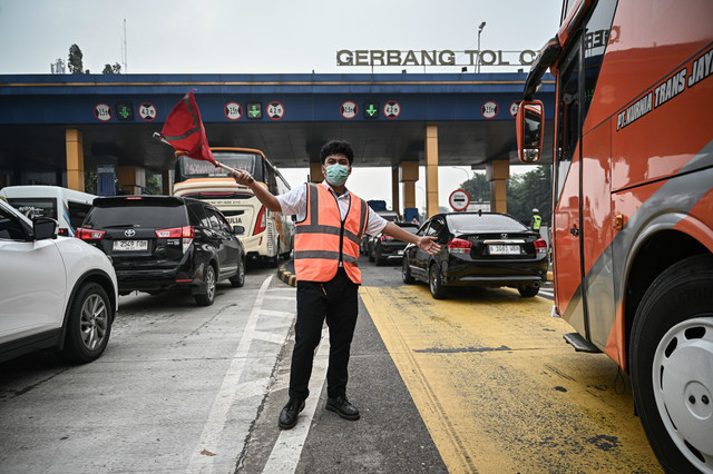 Petugas mengarahkan mobil menuju gerbang keluar tol saat sterilisasi jelang penerapan rekayasa lalu lintas satu arah atau one way di ruas Gerbang Tol Cikampek, Karawang, Jawa Barat, Jumat (27/3/2026).  Foto: Fauzan/ANTARA FOTO