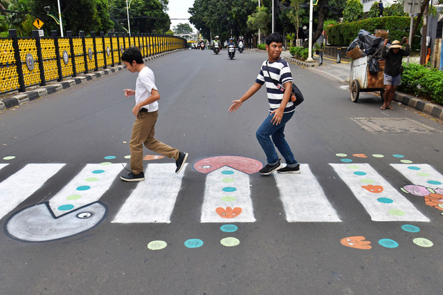 Pengguna jalan melintasi zebra cross buatan warga di Jalan Soepomo, Pancoran, Jakarta, Minggu (29/3/2026). Foto: Indrianto Eko Suwarso/ANTARA FOTO