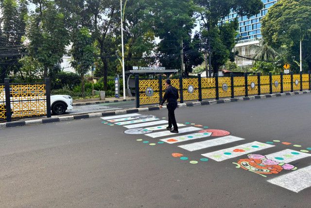 Warga yang tengah menyeberang di zebra cross bergambar di Jalan Dr. Soepomo, Jakarta Selatan, Minggu (29/3/2026). Foto: Ryan Iqbal/kumparan