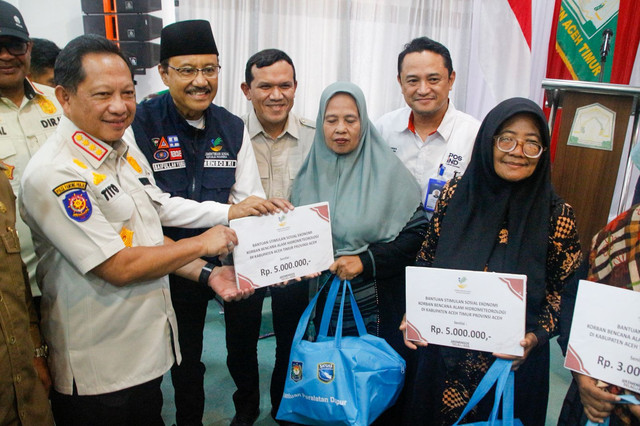 Kasatgas Percepatan Rehabilitasi dan Rekonstruksi Pascabencana Sumatera Muhammad Tito Karnavian (kiri) saat memberikan bantuan kepada penyintas bencana Sumatera. Foto: Satgas PRR