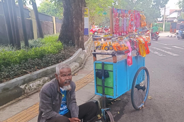 Abah Budi, penjual mainan keliling saat ditemui di Jalan Suren, Cihapit, Kota Bandung, Selasa (31/3/2026). Foto: Abisatya Ramdhani/kumparan