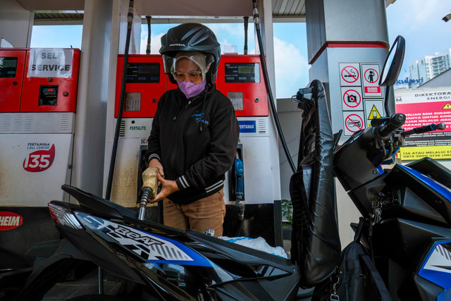 Para pengendara sepeda motor mengantre untuk mengisi bahan bakar sepeda motor mereka di sebuah SPBU di Jakarta pada Rabu (1/4/2026). Foto: Bay Ismoyo/AFP