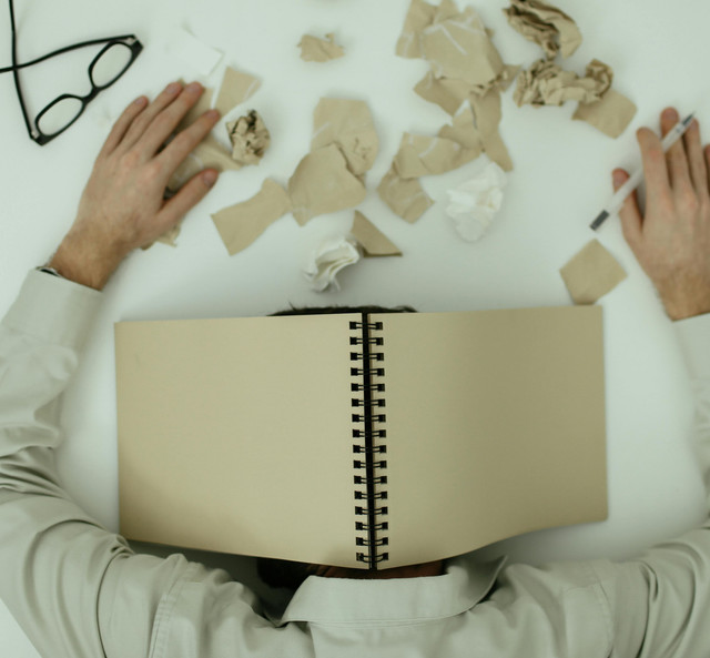 Ilustrasi pemuda berada di tumpukan berkas seolah sedang frustasi. Foto: Pexels