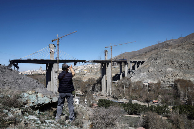 Seorang pria berdiri di dekat jembatan B1 yang rusak akibat serangan, saat konflik AS-Israel dengan Iran berlanjut, di Karaj, Iran, Jumat (3/4/2026). Foto: Majid Asgaripour/WANA via Reuters