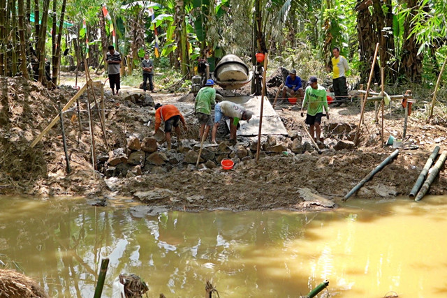 Warga tengah bahu-membahu membangun jembatan permanen di Kelurahan Sambeng. Foto: Dok. Bakom RI