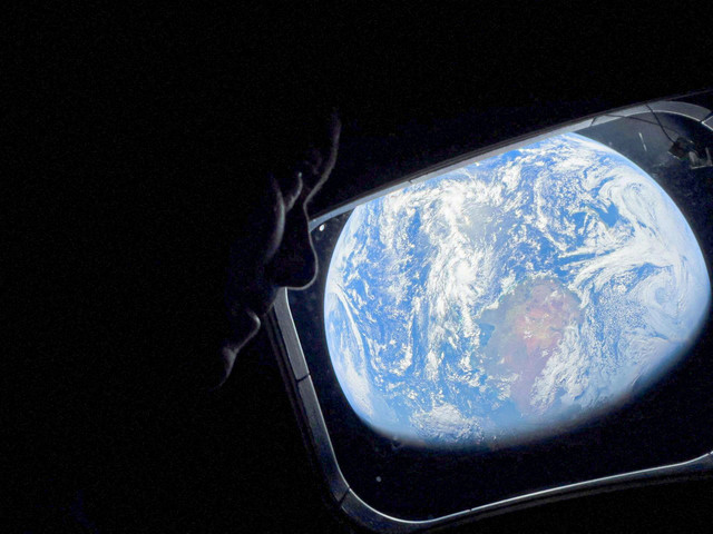 Astronot NASA dan Komandan Artemis II, Reid Wiseman, mengintip keluar dari salah satu jendela kabin utama pesawat ruang angkasa Orion, melihat kembali ke Bumi, saat kru melakukan perjalanan menuju Bulan pada 2 April 2026.  Foto: NASA/Handout via REUTERS 
