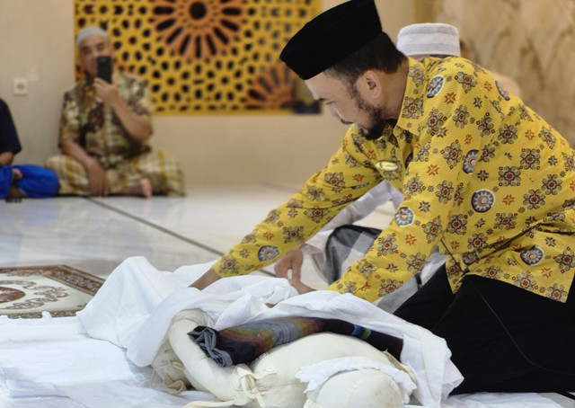 Narasumber mempraktikkan proses pemulasaran jenazah kepada masyarakat di Masjid Islamic Center Al-Muqarrabin, Dusun Cepit. (Foto: Syafa Arshinta Nabila)