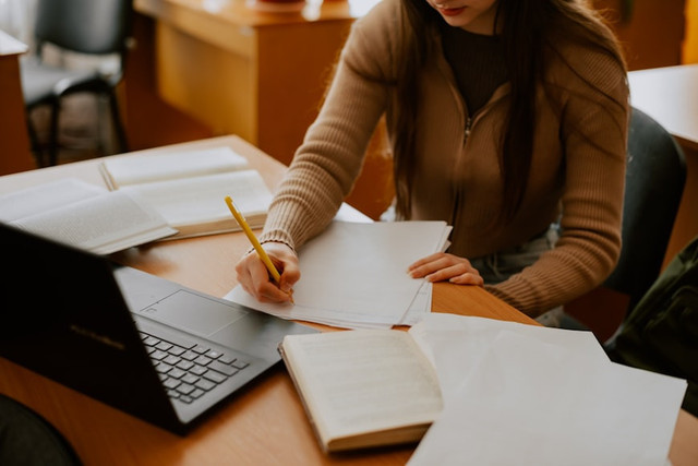 Ilustrasi wali kelas mengisi raport. Foto: Unsplash