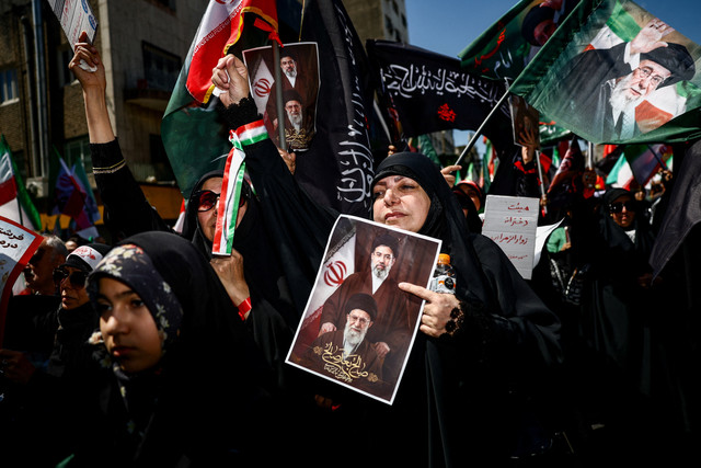 Seorang wanita memegang foto mendiang Pemimpin Tertinggi Iran Ayatollah Ali Khamenei dan Pemimpin Tertinggi Iran yang baru, Mojtaba Khamenei, selama upacara peringatan 40 hari kematian Ayatollah Ali Khamenei di di Teheran, Iran, Kamis (9/4/2026). Foto: Majid Asgaripour/WANA via REUTERS 