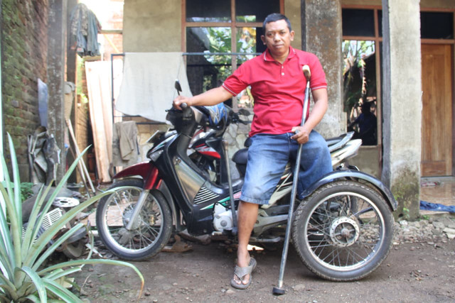Achmad Nur Zani menaiki sepeda motor roda tiga miliknya yang sudah dimodifikasi olehnya. Foto: Vega Maarijil Ula/kumparan