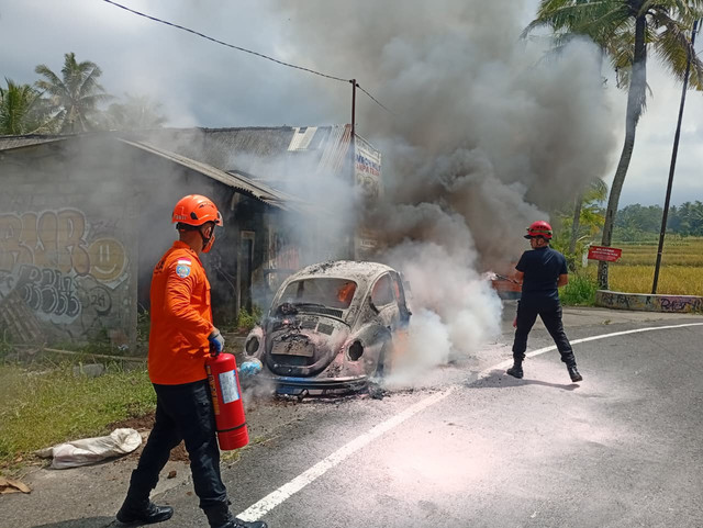 Sebuah mobil Volkswagen (VW) hangus terbakar di Jalan Cangkringan-Pakem, Dusun Tanjung, Wukirsari, Kapanewon Cangkringan, Kabupaten Sleman, Jumat (10/4/2026). Foto: Dok. Basarnas Yogyakarta
