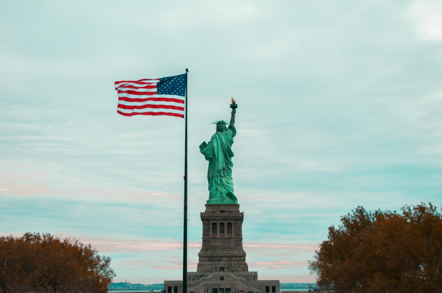 Foto Patung Liberty sebagai monumen ikonik di New York, AS, yang melambangkan kebebasan dan demokrasi; serta bendera nasional Amerika Serikat. (Sumber: Pexels)