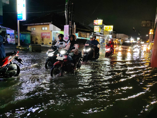 Air meluap genangi Jalan Godean, Kabupaten Sleman usai hujan deras, Jumat (10/4/2026). Foto: Arfiansyah Panji Purnandaru/kumparan