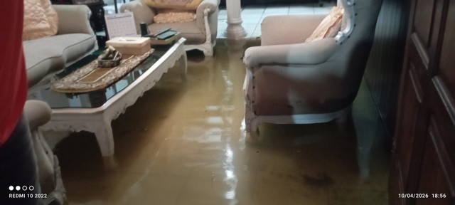 Petugas menyedot air yang menggenang di ruang tamu salah satu rumah warga di Perumahan Nogotirto, Kapanewon Gamping, Kabupaten Sleman, Jumat (10/4). Foto: BPBD Sleman
