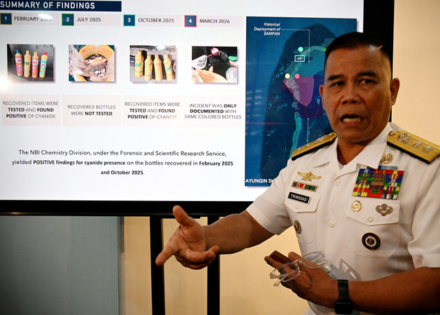 Juru bicara Angkatan Laut Filipina, Laksamana Muda Roy Vincent Trinidad, berbicara di samping presentasi slide tentang botol-botol kuning yang disita dan diduga berisi sianida di perairan Second Thomas Shoal di Laut Cina Selatan. Foto: Ted Aljibe/AFP