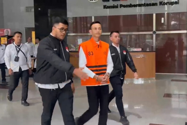 Ajudan mantan Gubernur Riau Abdul Wahid Marjani mengenakan baju tahanan berjalan menuju mobil tahanan usai menjalani pemeriksaan di Gedung Merah Putih KPK, Jakarta, Senin (13/42026). Foto: Dok. Istimewa