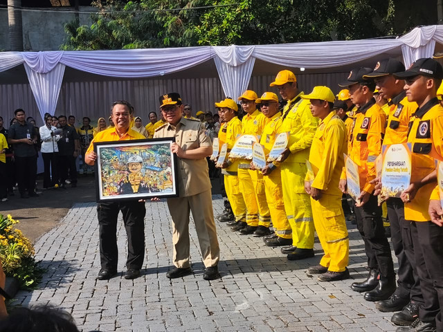 Gubernur DKI Jakarta, Pramono Anung, saat memberikan cinderamata kepada Kepala Dinas Bina Marga, Heru suwondo, dalam acara silaturahmi bersama Pasukan Kuning Dinas Bina Marga Provinsi DKI Jakarta, Jakarta Timur, Selasa (14/4/2026). Foto: Jeni Ritanti/kumparan