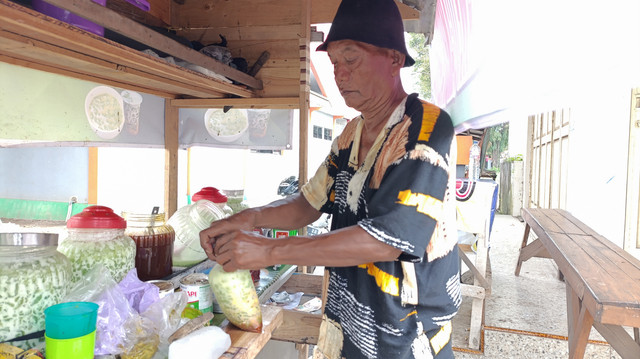 So'un (50) sedang membuat menu es cendol. Foto: Vega Ma'arijil Ula/kumparan