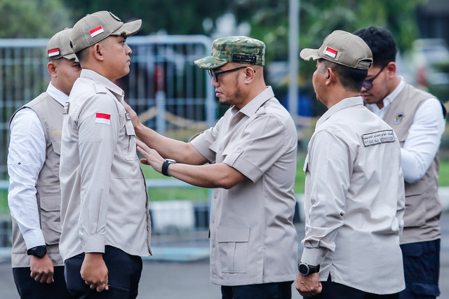 Wakil Menteri Haji dan Umrah Dahnil Anzar Simanjuntak (tengah) menyematkan simbol Petugas Penyelenggara Ibadah Haji (PPIH) kepada perwakilan petugas di Asrama Haji Pondok Gede, Jakarta, Jumat (17/4/2026).  Foto: Asprilla Dwi Adha/ANTARA FOTO