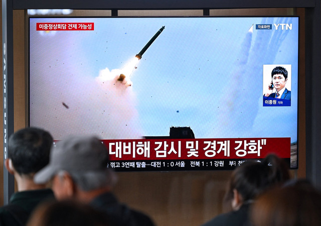 Layar televisi yang menampilkan siaran berita dengan cuplikan arsip uji coba rudal Korea Utara, di stasiun kereta api di Seoul, Korea Selatan, Minggu (19/4/2026). Foto: Jung Yeon-je / AFP