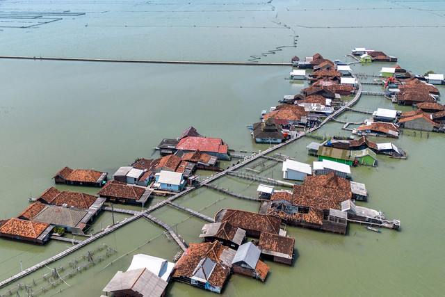 Pemandangan udara menunjukkan rumah-rumah yang sebagian terendam air laut akibat banjir pasang surut di sepanjang pantai. Foto: Devi Rahman/AFP