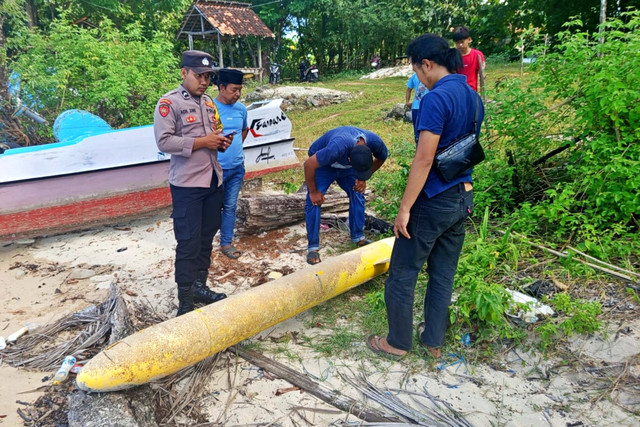 Petugas mengecek benda diduga torpedo yang ditemukan di bibir pantai Dusun Aenglombi, Desa Torjek, Kecamatan Kangayan, Pulau Kangean, Kabupaten Sumenep pada Senin (20/4/2026). Foto: Dok. Polres Sumenep