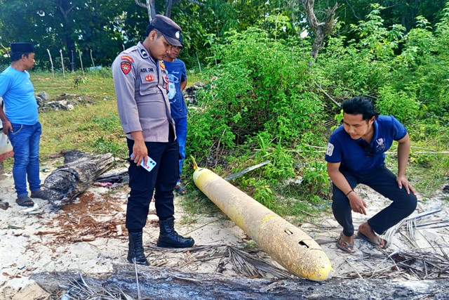 Petugas mengecek benda diduga torpedo yang ditemukan di bibir pantai Dusun Aenglombi, Desa Torjek, Kecamatan Kangayan, Pulau Kangean, Kabupaten Sumenep pada Senin (20/4/2026). Foto: Dok. Polres Sumenep