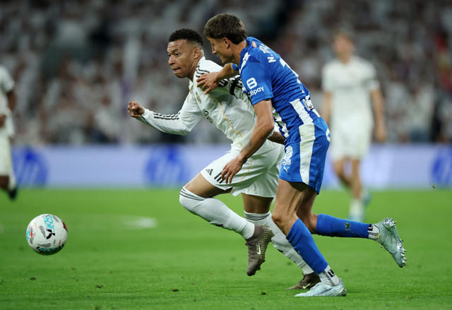 Kylian Mbappe dari Real Madrid beraksi bersama Nahuel Tenaglia dari Deportivo Alaves pada pertandingan Liga Spanyol antara Real Madrid vs Deportivo Alaves di Santiago Bernabeu, Madrid, Rabu (22/4/2026) dini hari WIB. Foto: Isabel Infantes/REUTERS