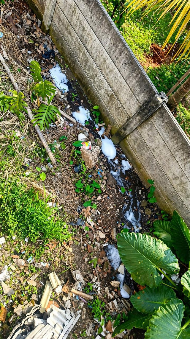 Judul Foto:Pembuangan Limbah MBG di Area TerbukaCaption:Limbah MBG terlihat dibuang sembarangan di saluran air dekat lingkungan warga, berisiko mencemari tanah dan air.Kredit:Dokumentasi pribadi / Nova Dwiaryanti (2026)