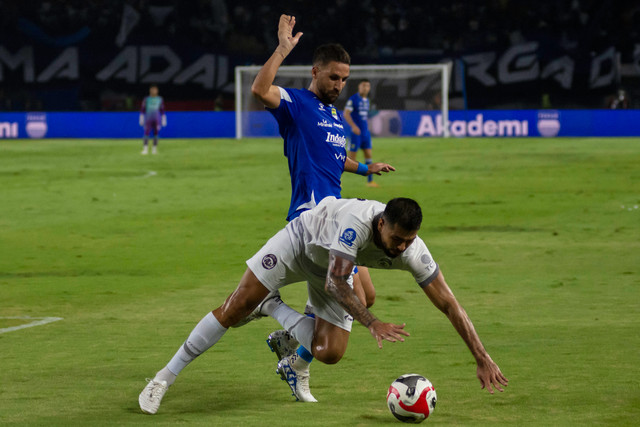 Pesepak bola Arema FC Sneyder Guevara nyaris terjatuh saat berebut bola dengan pemain Persib Bandung Luciano Guaycochea dalam pertandingan lanjutan BRI Super League di Stadion Gelora Bandung Lautan Api (GBLA), Bandung, Jawa Barat, Jumat (24/04/2026). Foto: Abdan Syakura/ANTARA FOTO